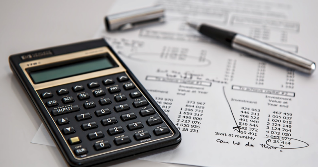 Calculator and pen used to add up the costs of buying a boat for beginners