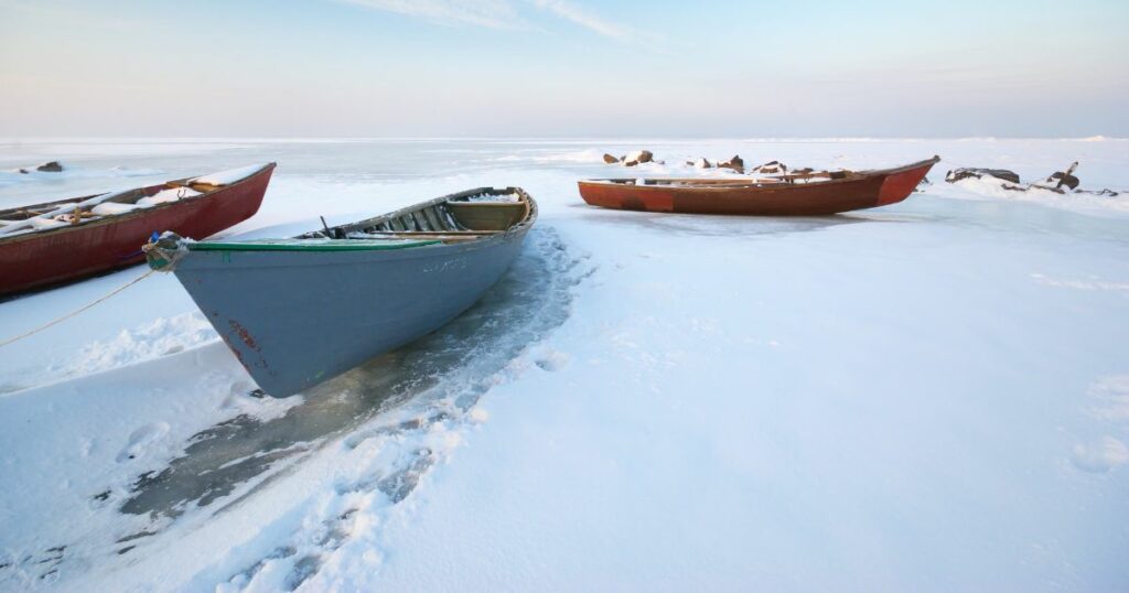3 boats on a frozen lake in winter